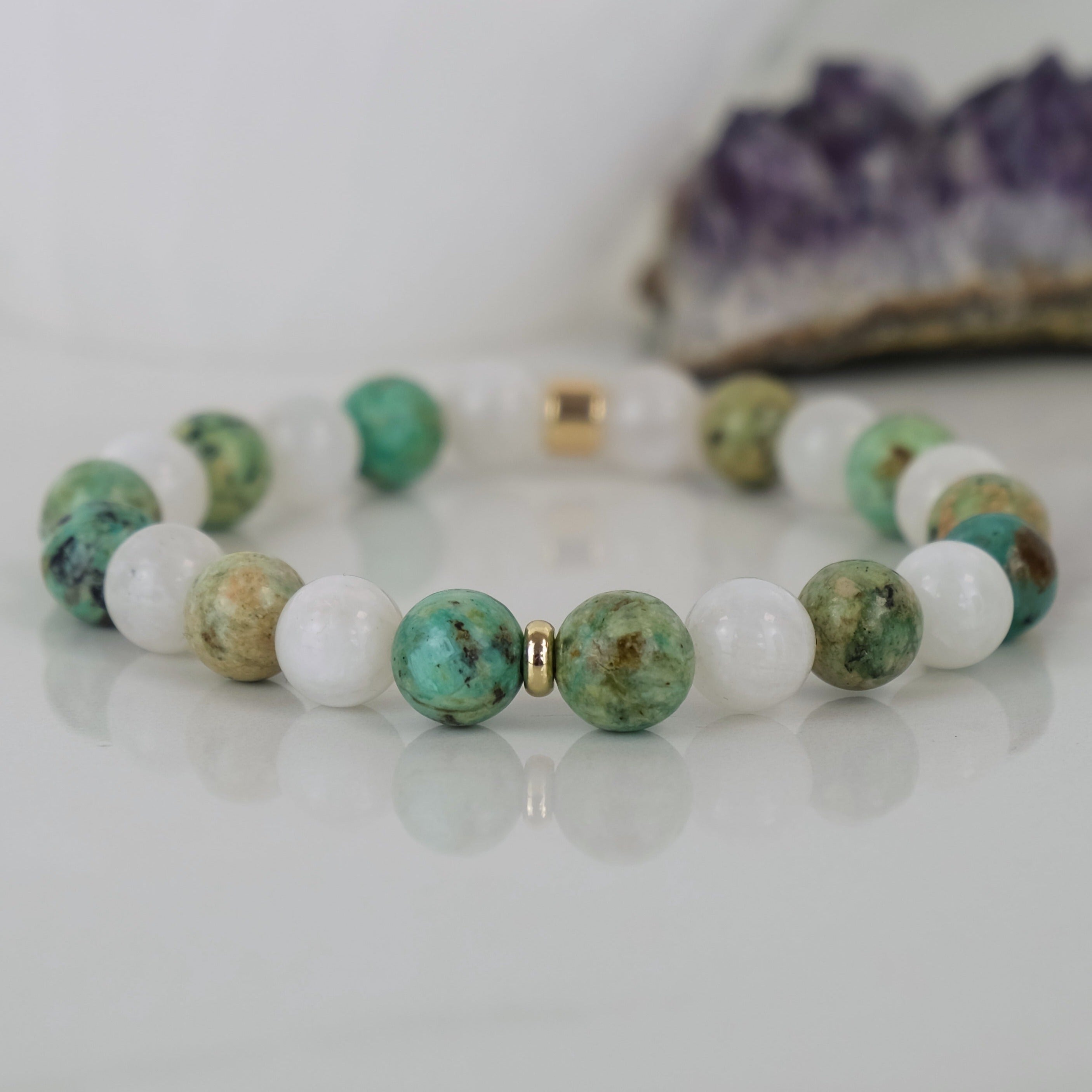 A moonstone and chrysocolla gemstone bracelet with gold accessories
