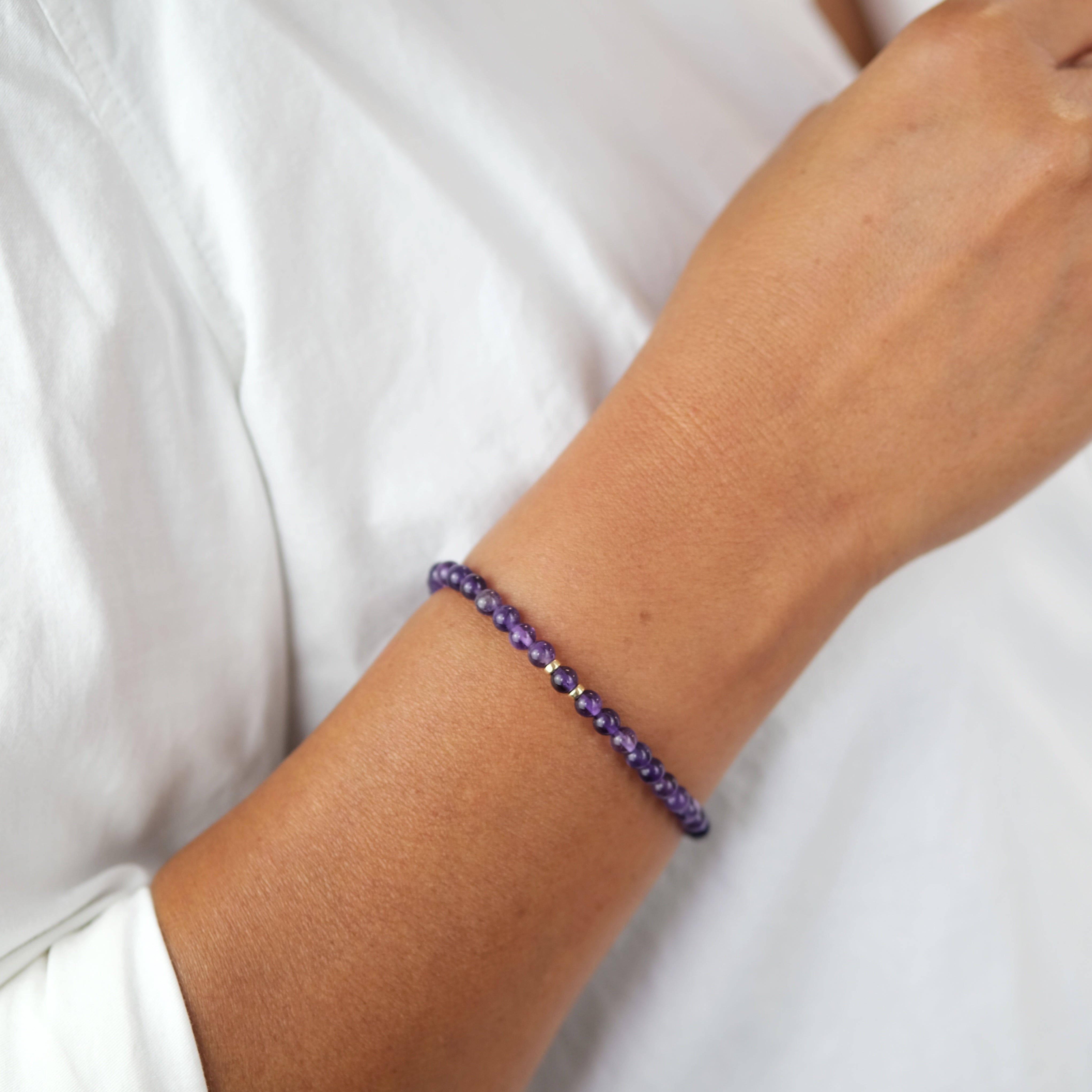 A model wearing Amethyst gemstone bracelet in 4mm beads with gold filled accessories