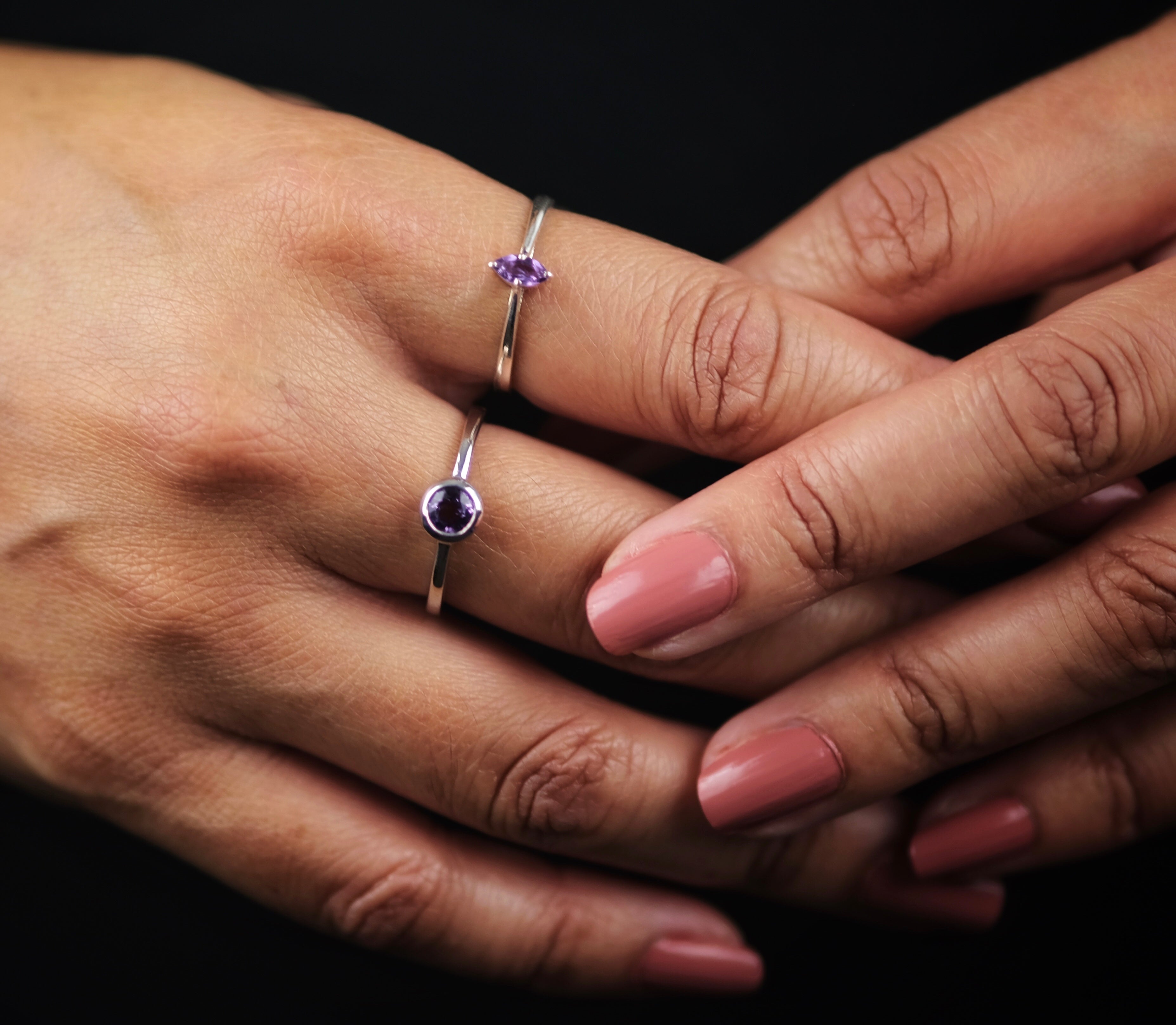 A model wearing two amethyst gemstone rings