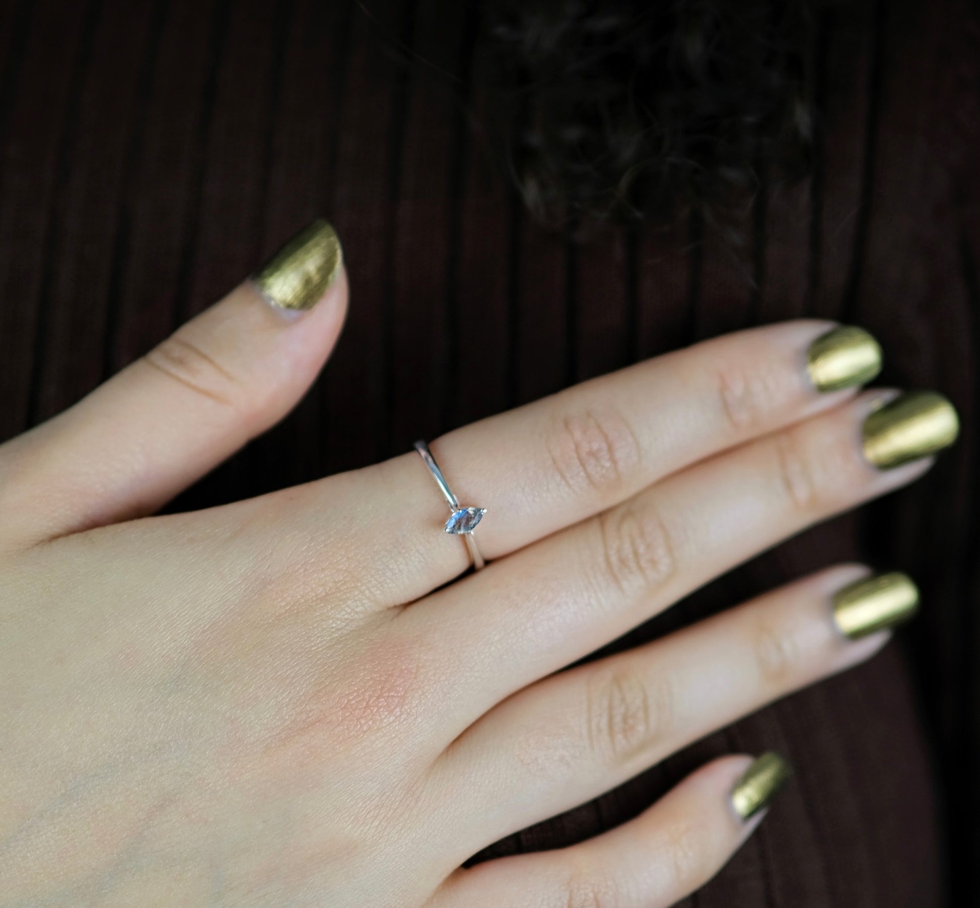 A model wearing A labradorite minimal marquis gemstone ring in silver