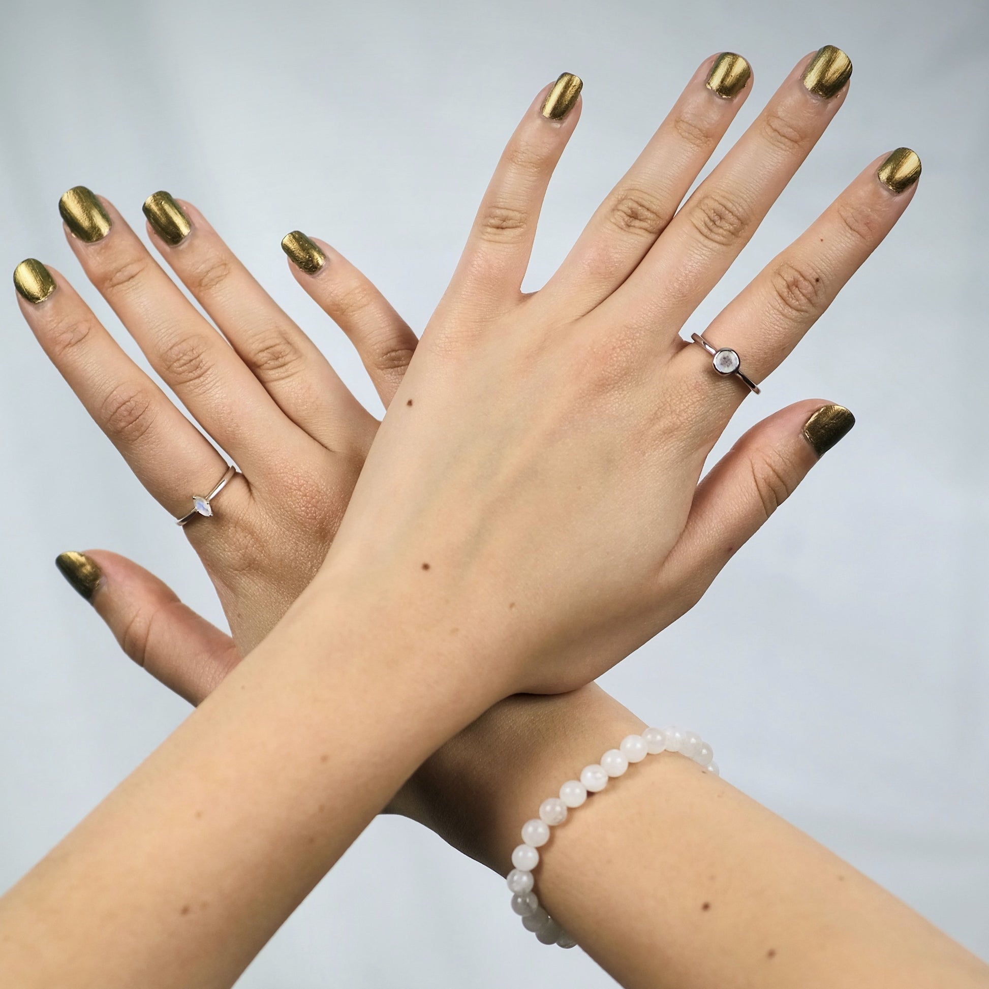 A model wearing moonstone gemstone rings and a bracelet