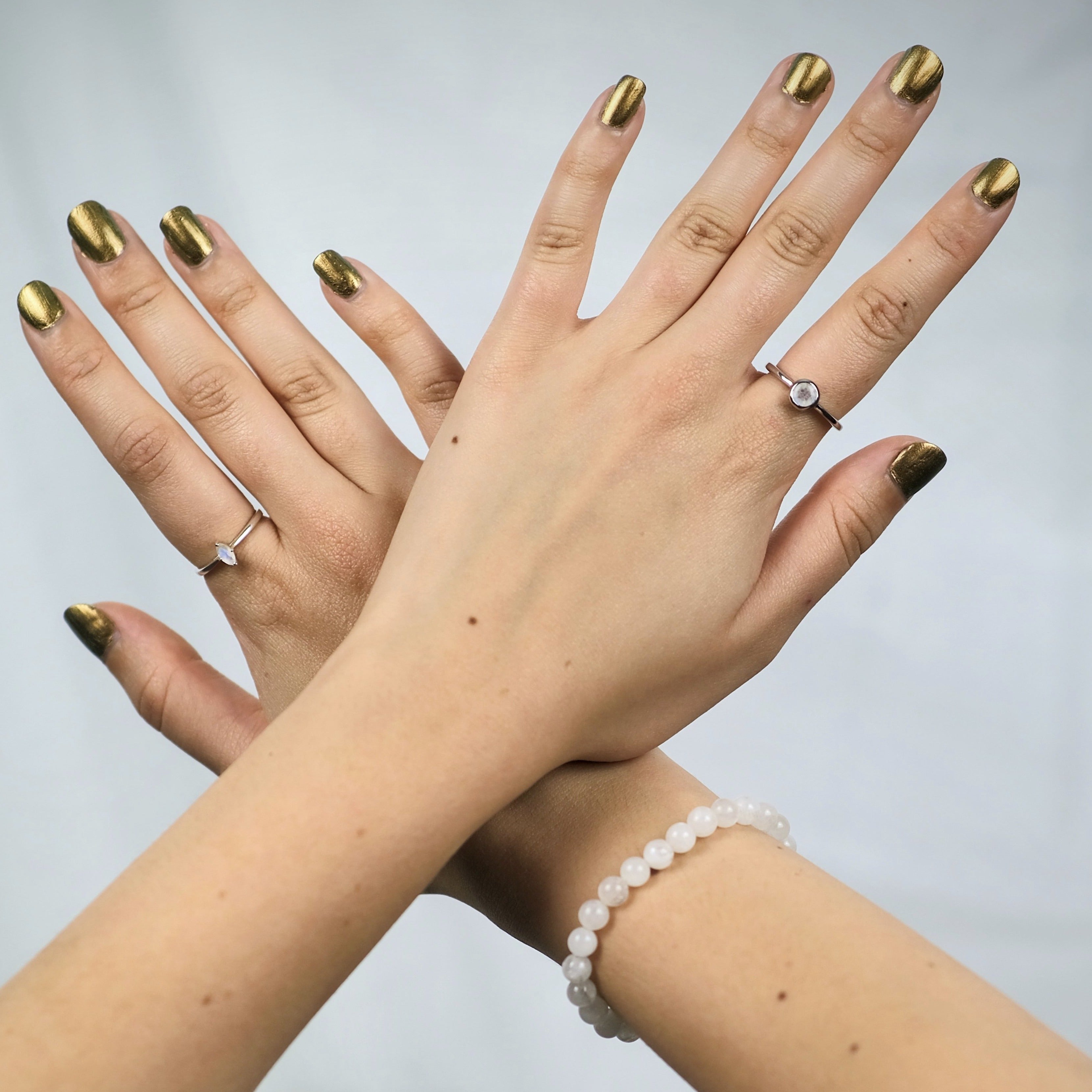 A model wearing moonstone gemstone rings and a bracelet