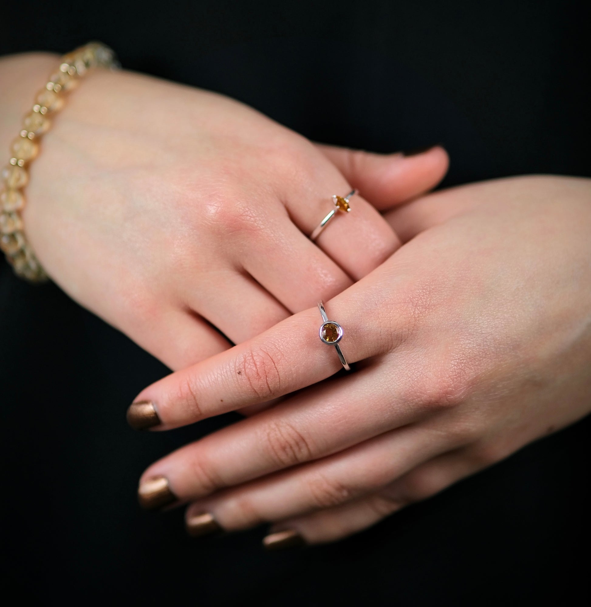 A model wearing two citrine gemstone rings