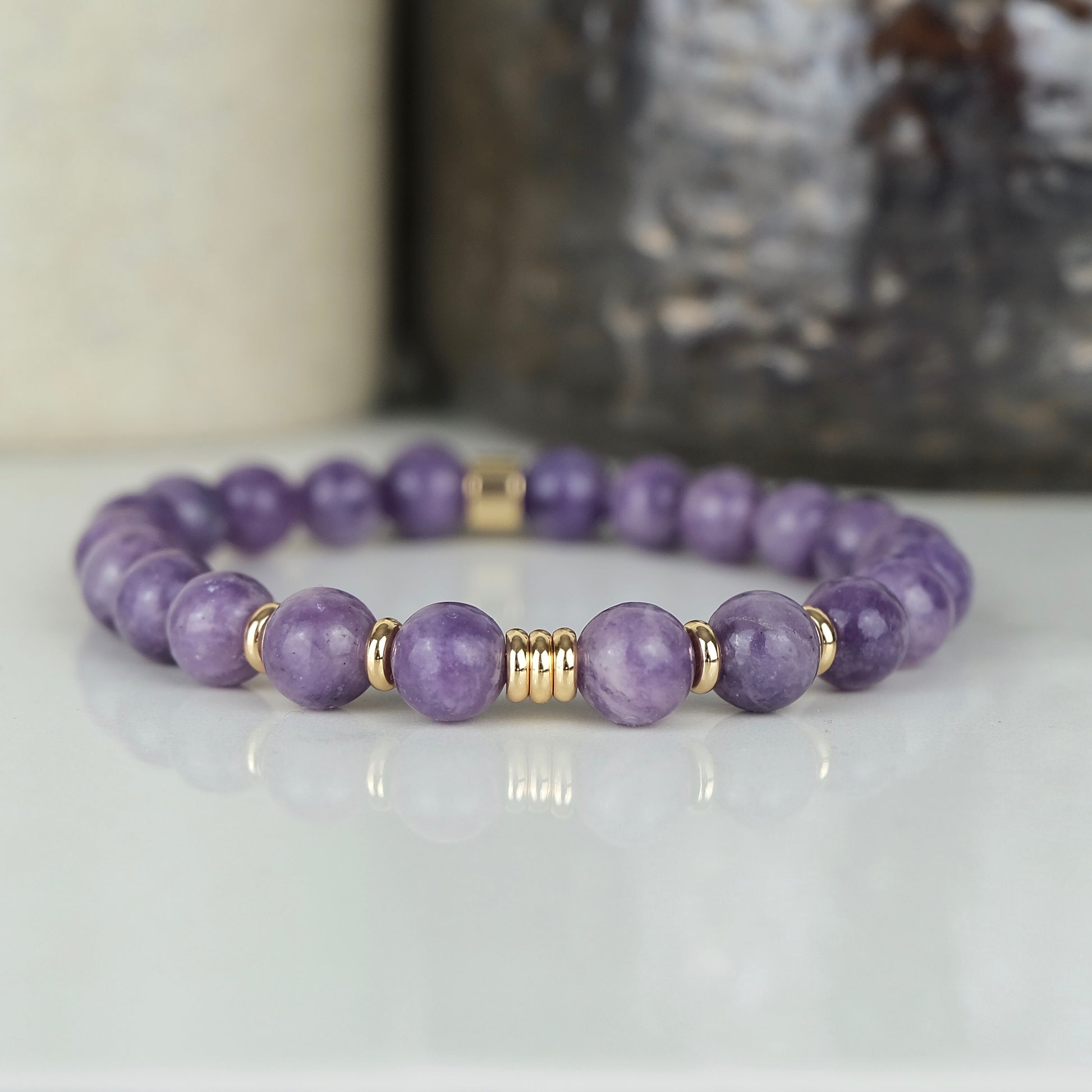 A lepidolite gemstone bracelet with gold accessories