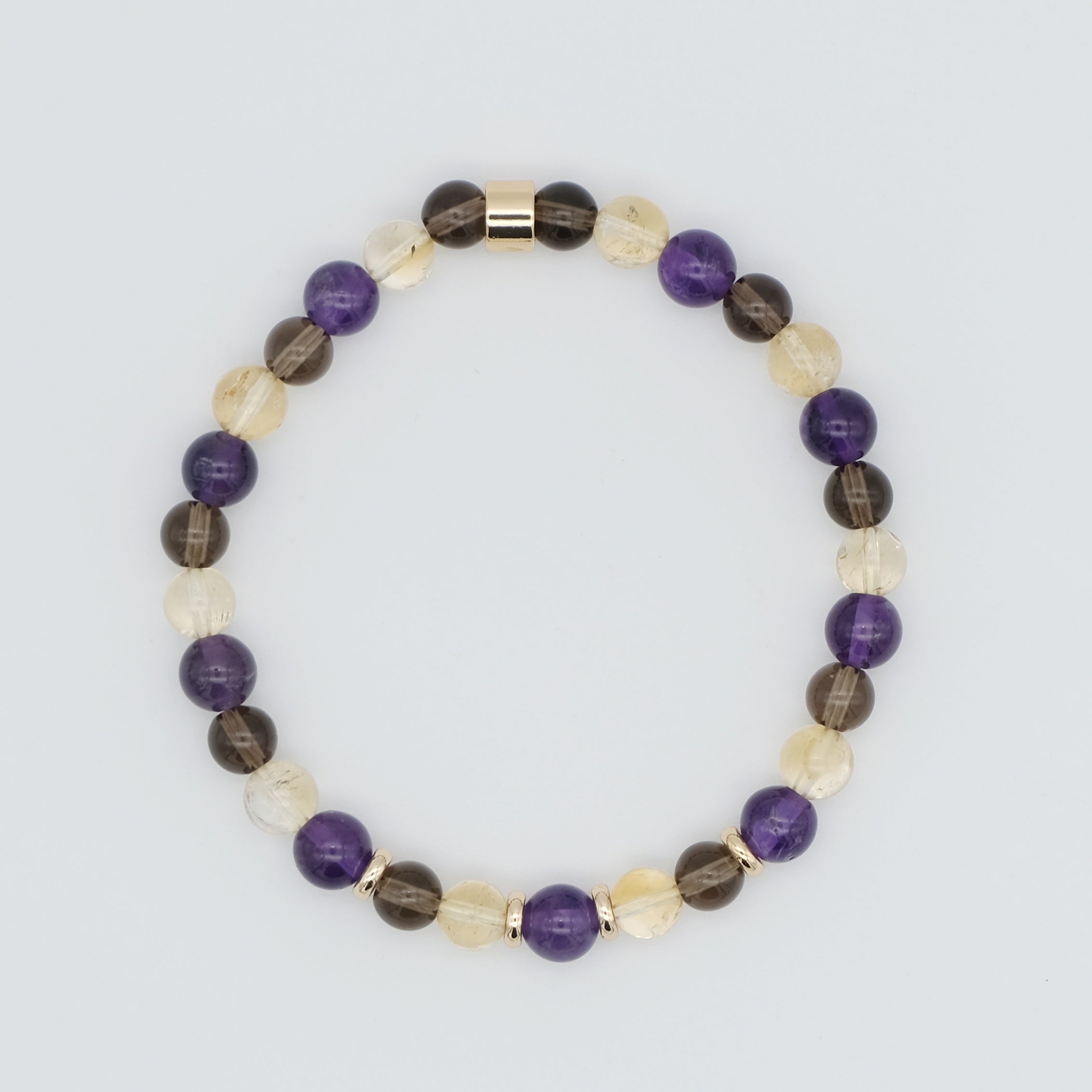 An Amethyst, citrine and smoky quartz gemstone bracelet in 6mm beads with gold accessories from above
