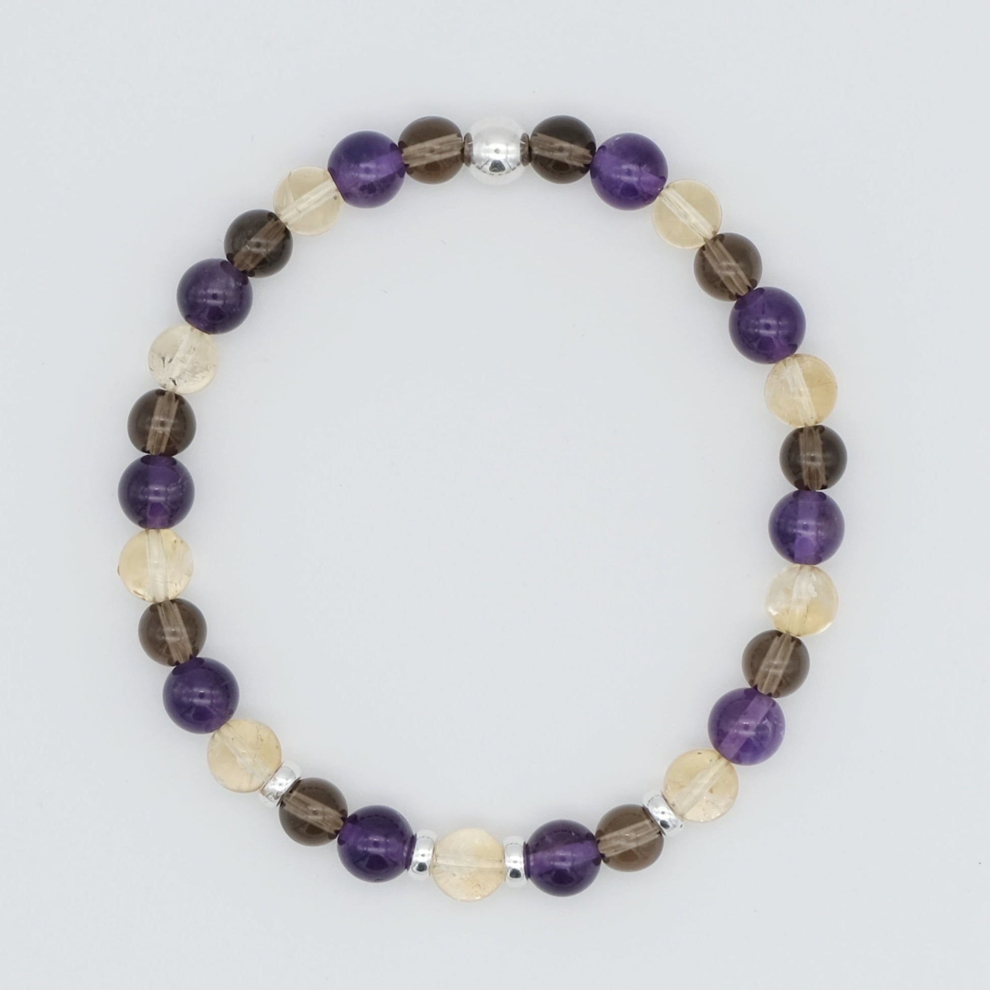 An Amethyst, citrine and smoky quartz gemstone bracelet in 6mm beads with silver accessories from above