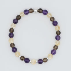 An Amethyst, citrine and smoky quartz gemstone bracelet in 6mm beads with silver accessories from above