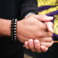 A model wearing onyx and hematite gemstone bracelets in 10mm beads with stainless steel accessory