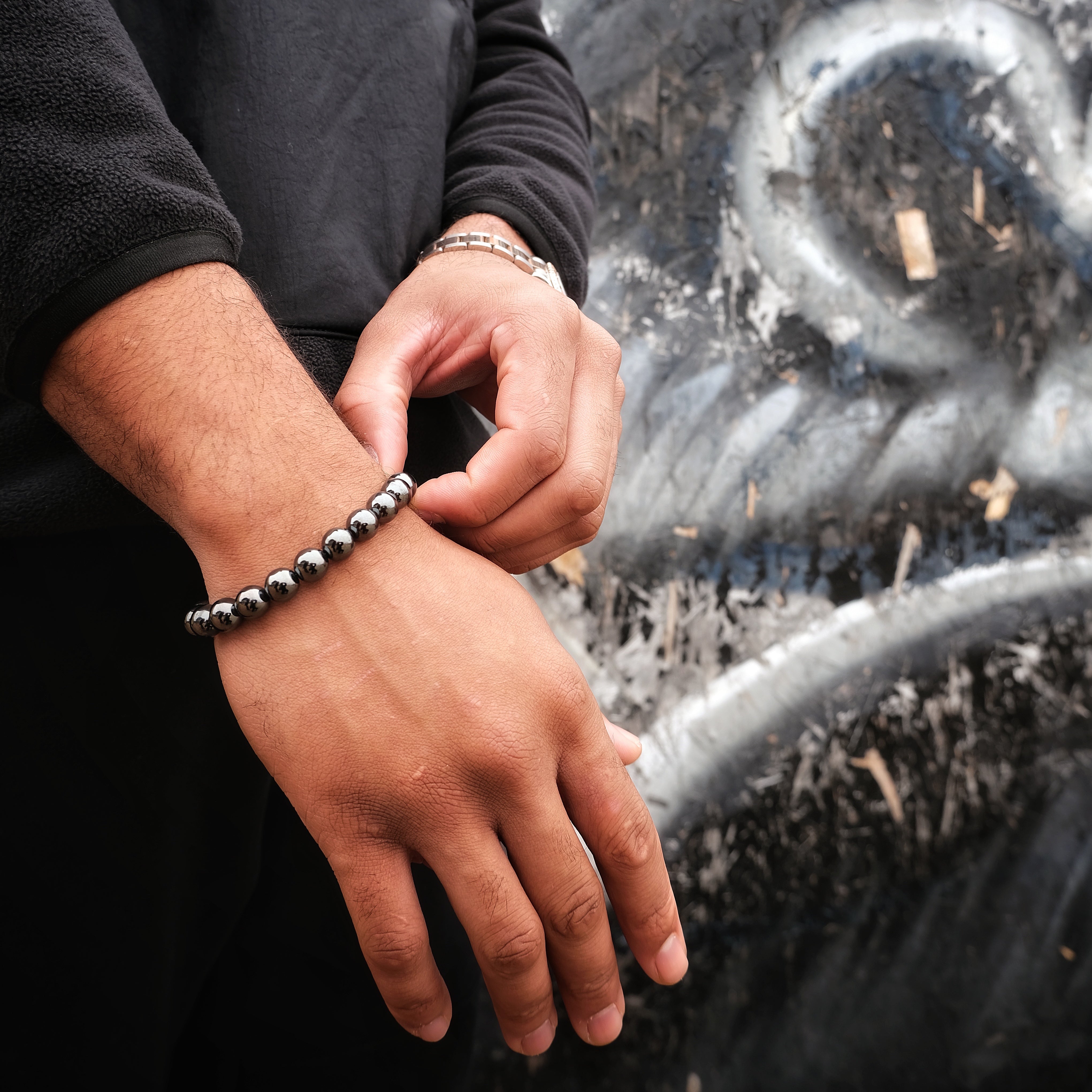A model wearing a hematite gemstone bracelet in 10mm beads with steel accessory