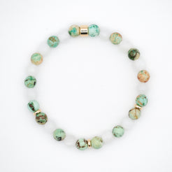 A moonstone and chrysocolla gemstone bracelet in 6mm beads with gold accessories from above