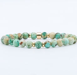 A chrysocolla gemstone bracelet in 6mm beads with gold accessories