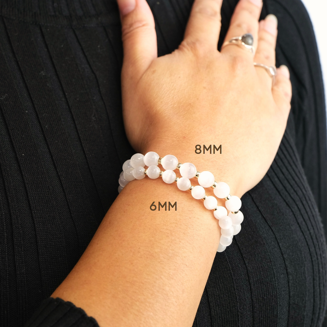 Selenite gemstone bracelet worn on a model's wrist in both 6mm and 8mm beads